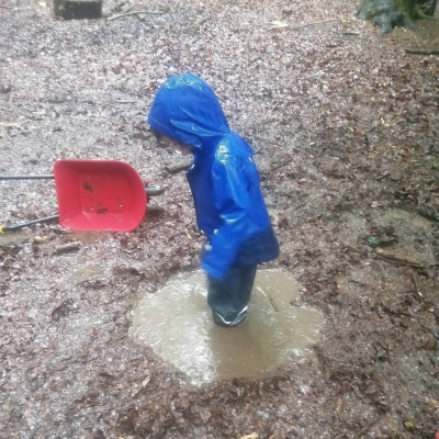 Child jumping in puddle